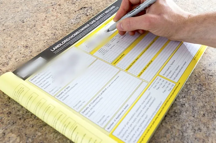 Landlord gas safety record being filled in